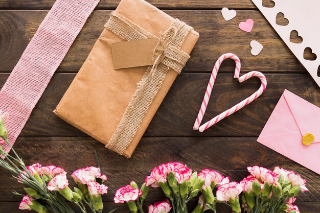 Gift box between flowers, envelope and candy canes