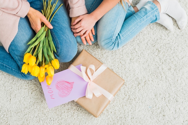 Gift box with Mother`s day postcard near woman and girl