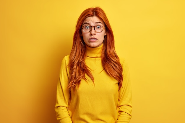 Free photo ginger european woman stares surprised feels excited wears casual turtleneck.