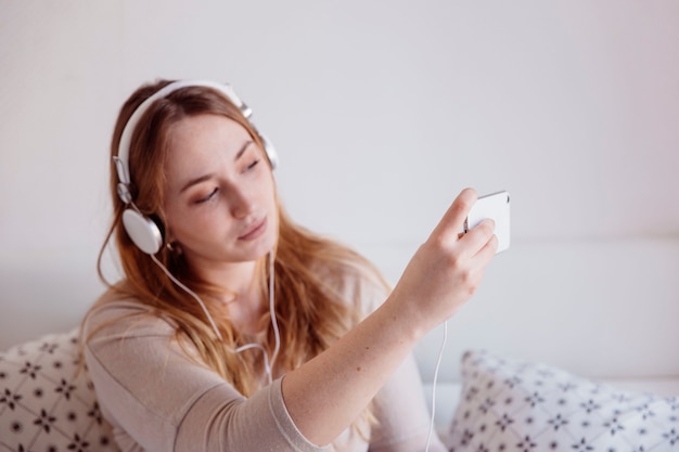 Free Photo ginger woman in headphones taking selfie