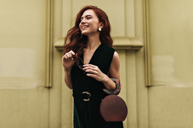 Free photo ginger woman holds handbag and smiles