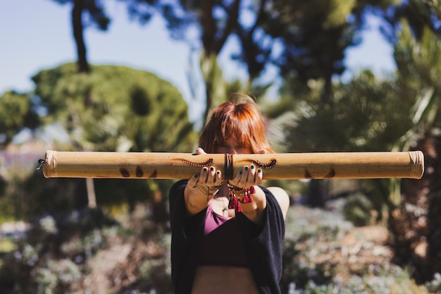 Free photo ginger woman showing bamboo stick