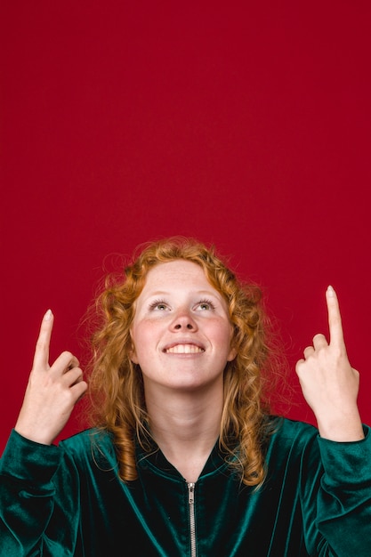 Ginger young woman looking and pointing up