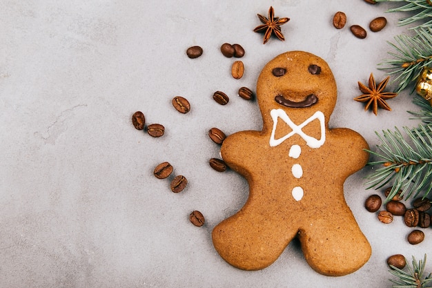 Free photo gingerbread, coffee beans and fir lie on grey floor