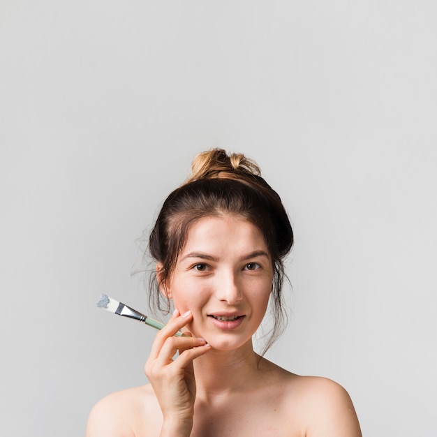 Girl applying herself cosmetic product