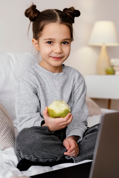 Free Photo girl in bed watching video on laptop