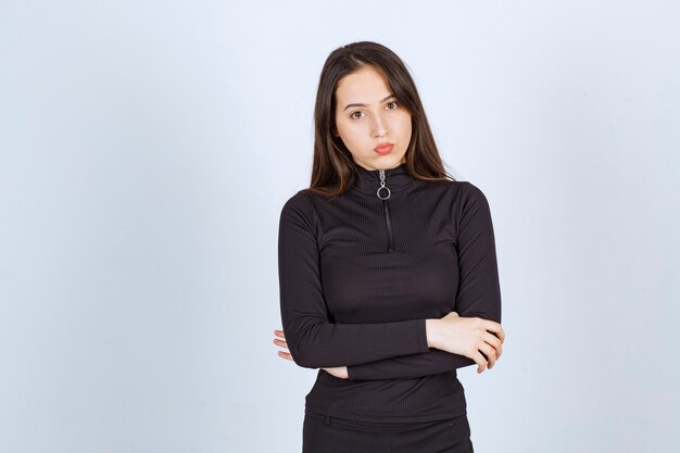 Girl in black clothes giving professional and neutral poses without reaction. 