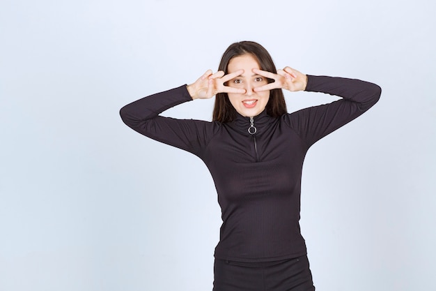 Girl in black clothes showing peace and friendship sign. 