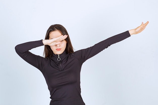 Girl in black clothes trying to stop something. 