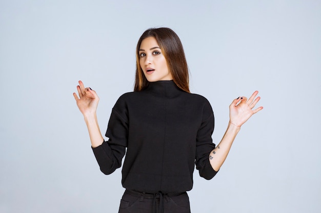 Free photo girl in black shirt showing positive hand sign. high quality photo