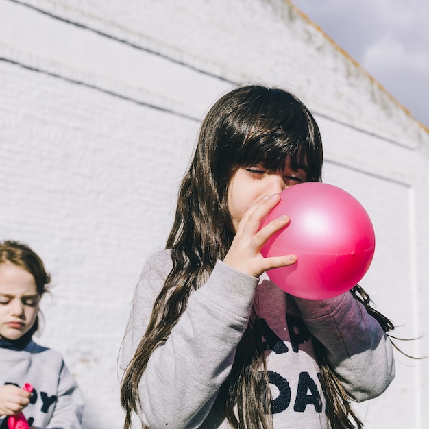 Free photo girl blowing up balloon