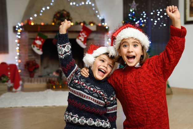 Free photo girl and boy celebrating with one arm raised