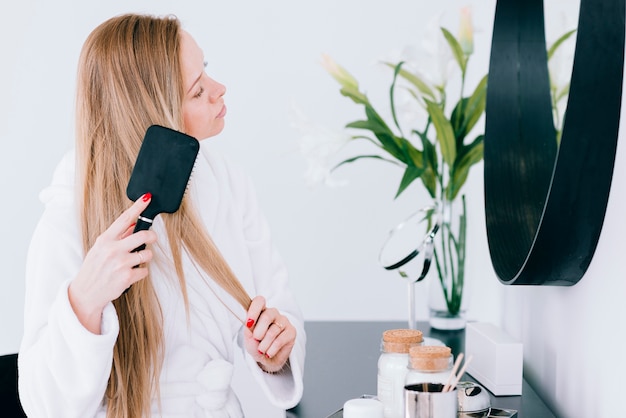 Free Photo girl brushing her hair at the bathroom