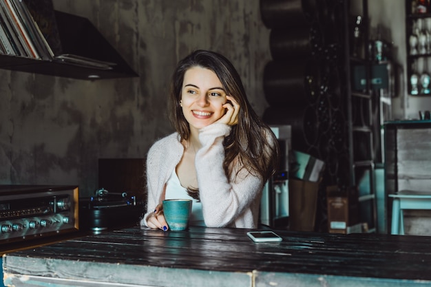 Free photo girl in a cafe with a smartphone