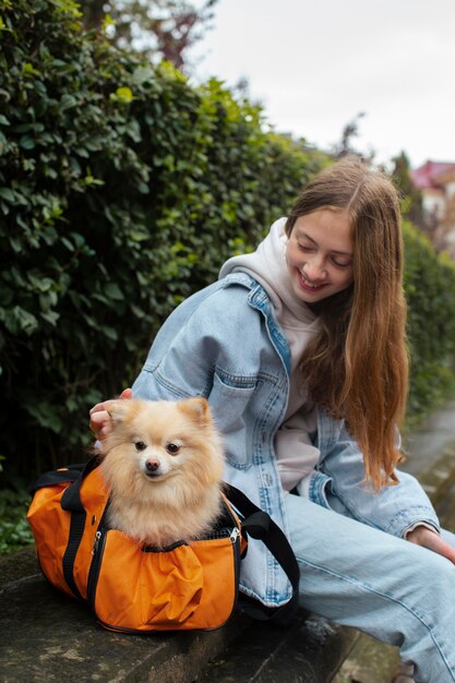 Girl carrying puppy in bag side view