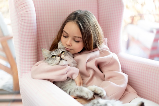 Girl and cat sitting in an armchair