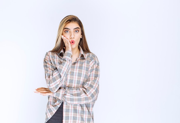 Girl in checked shirt looks scared and terrified