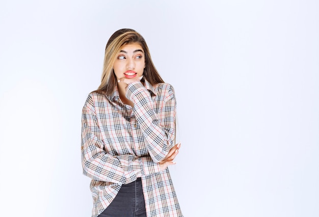 Girl in checked shirt looks scared and terrified