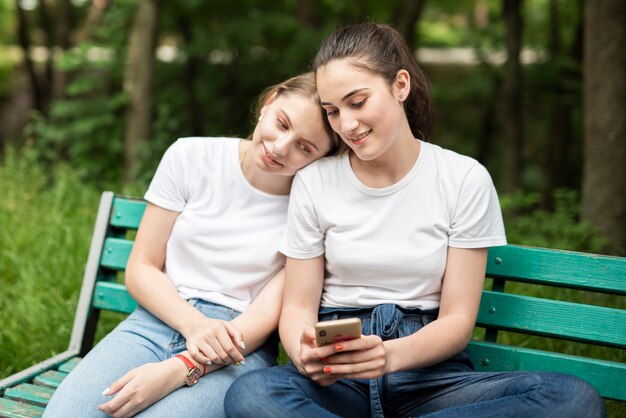 Girl checking her phone with friend