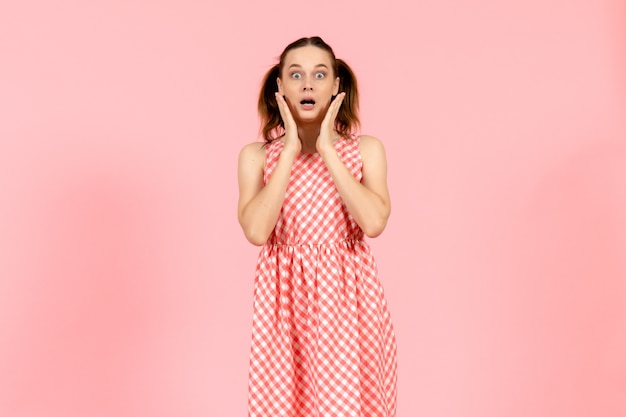 girl in cute bright dress with surprised expression on pink