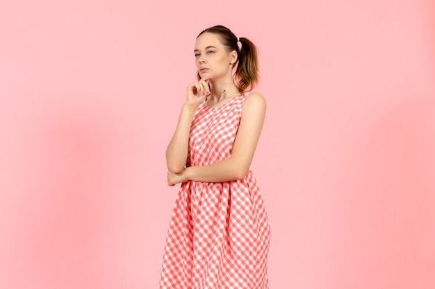 Free photo girl in cute bright dress with thinking expression on pink