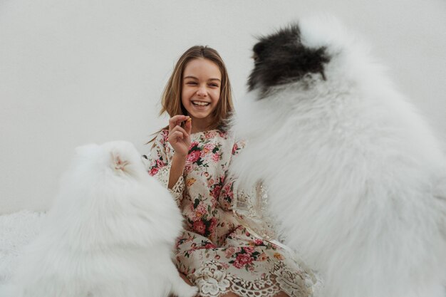 Girl and cute white puppies playing fetch