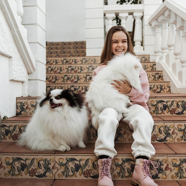 Girl and cute white puppies sitting on the stairs