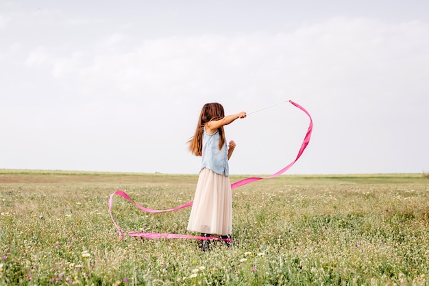 Free photo girl dancing with gymnastic ribbon in field