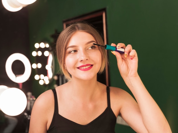 Girl doing her make up in a green room