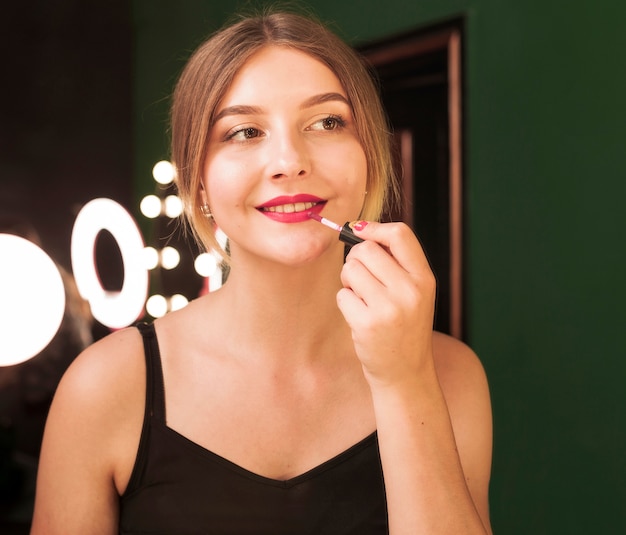 Free photo girl doing her make up in a green room