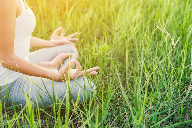 Free Photo girl doing yoga sitting in the field