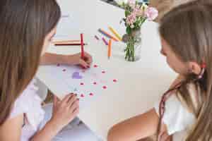 Free photo girl drawing hearts on paper