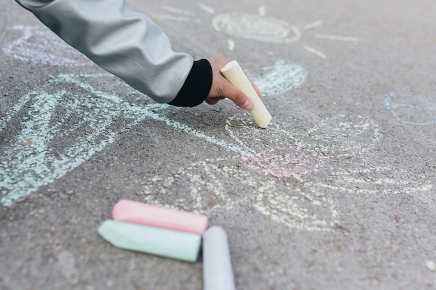 Free photo girl drawing with chalk on road