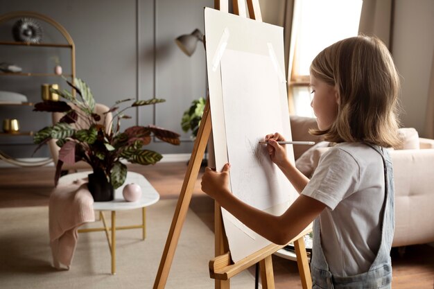 Girl drawing with pencil medium shot