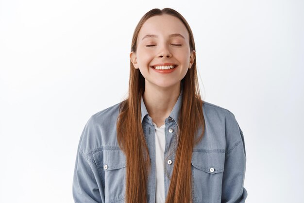 Girl dreaming Happy smiling woman close her eyes and imaging something remember beautiful moment daydreaming standing over white background