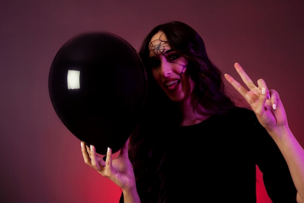 Free photo girl dressed as witch with balloon