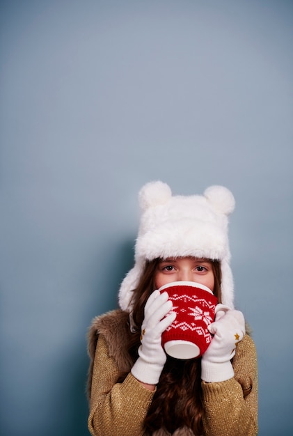 Free photo girl drinking hot chocolate at studio shot