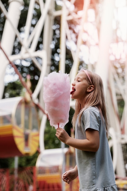 Girl eating cotton candy side view