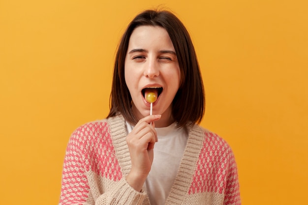 Free Photo girl eating lollipop and winking