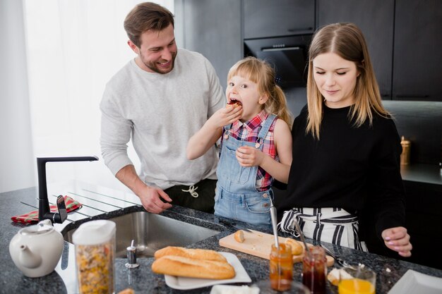 Girl eating near parents