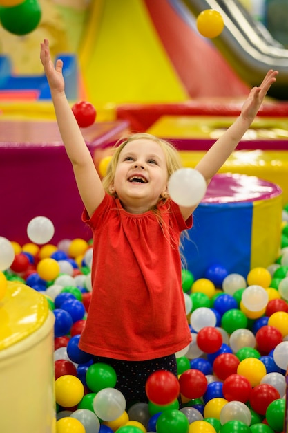 Free photo girl enjoying colorful ball pit