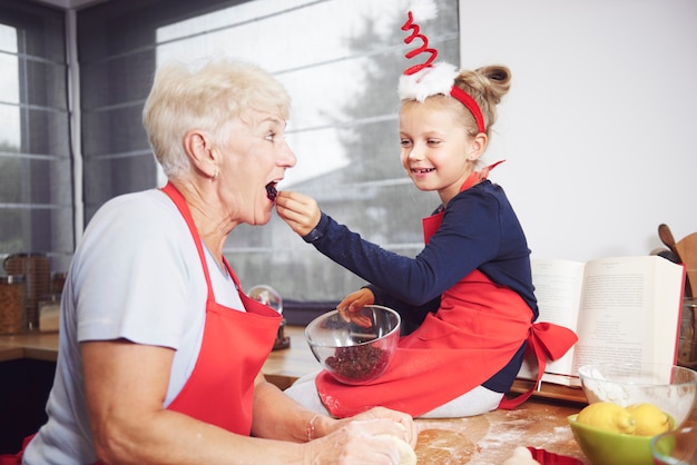 Girl feeding her grandmother with dried fruit