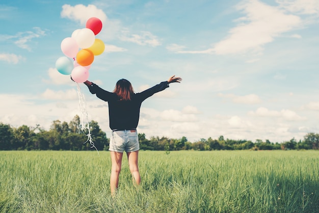 Free photo girl in a field with balloons