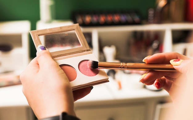 Girl filling brush with make up