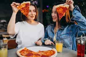 Free photo girl friends having pizza at a bar at a lunch time