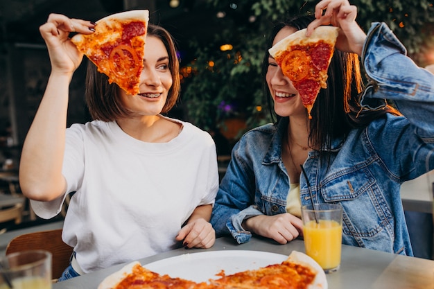 Free photo girl friends having pizza at a bar at a lunch time