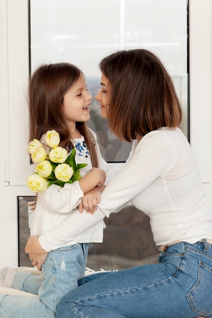 Free photo girl giving flowers to mother