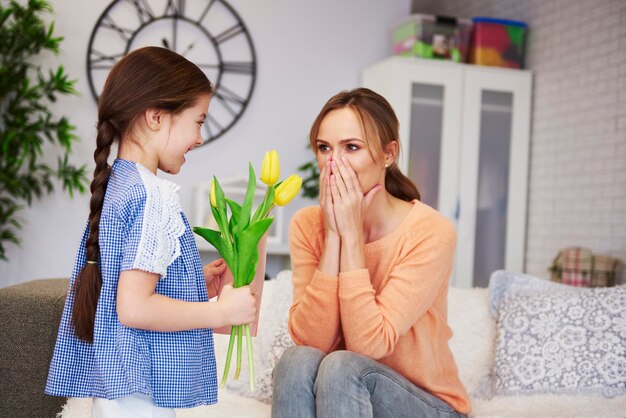 Girl giving her mom the flowers and greeting card