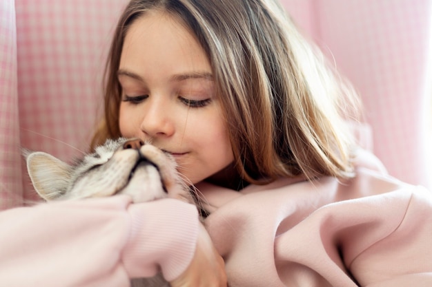 Free photo girl giving hisses to her beautiful cat