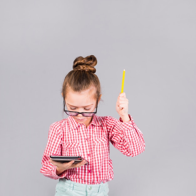 Free photo girl in glasses with pen using tablet